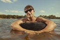 Retro man in summer lake have fun with inner tube Royalty Free Stock Photo