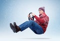 Funny man in sweater, scarf and hat, driving car with the steering wheel. Winter, snow, blizzard Royalty Free Stock Photo