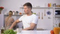 Funny man throwing away unappetizing food cooked by wife, couple relationship