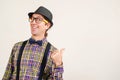 Funny man wearing retro clothes showing thumb up on white wall, copy space. Excited man in glasses shows like sign thumbs up and