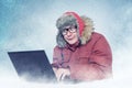 Funny man in winter clothes with laptop, cold, snow