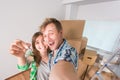 Funny married couple with boxes and holding flat keys Royalty Free Stock Photo