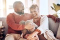 Funny mature couple laughing on living room sofa, couch and apartment for love, care or easy lifestyle together. Smile Royalty Free Stock Photo