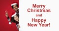 Funny millennial guy and woman in Santa Claus hats peeking out from behind billboard with inscription