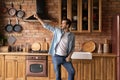 Funny millennial man enjoy cooking dance at modern wooden kitchen Royalty Free Stock Photo