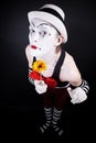 Funny mime in white hat with a bouquet of flowers