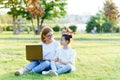 Funny mom and daughter with modern laptop outdoors Royalty Free Stock Photo