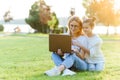 Funny mom and daughter with modern laptop outdoors Royalty Free Stock Photo