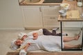 Funny mom and son relax in the kitchen after cooking. A tired woman and a boy are lying on the kitchen floor Royalty Free Stock Photo