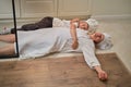 Funny mom and son relax in the kitchen after cooking. A tired woman and a boy are lying on the kitchen floor Royalty Free Stock Photo