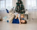funny mom and son 4-6 years old are playing lying on the floor against the background of the Christmas tree Royalty Free Stock Photo