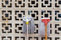 Funny mops heads against vent wall. Used wet floor mops drying on sun by lean on garage or warehouse air brick vent wall Royalty Free Stock Photo