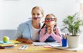 Funny mother and child daughter doing homework writing and reading Royalty Free Stock Photo