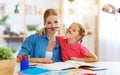 Funny mother and child daughter doing homework writing and reading Royalty Free Stock Photo