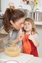 Funny mother and child tasting whipped cream with finger