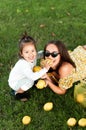 Funny mum with the daughter play with lemons lying on a grass Royalty Free Stock Photo