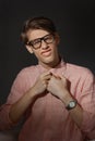 Funny nerd. Creative teen millenial portrait indoors. Funny young man with happy face expression in glasses against dark