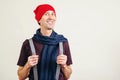 Funny nerd guy pulling his suspenders. Trendy hipster in hat and scarf on grey wall, with copy space. Young man with new idea