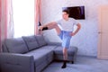 Funny nerd man is doing forward slopes and stretching exercises for legs at home. Sport humor concept.