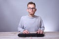 Funny nerd young businessman, man working on computer.Typing on the keyboard programmer in glasses in front of computer Royalty Free Stock Photo