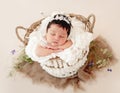 Funny newborn in basket on stomach