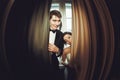 Funny newlyweds stand behind the beig curtains Royalty Free Stock Photo