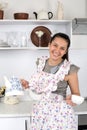 The funny nice housewife in kitchen prepares tea.