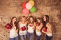 Funny nice-looking girls holding birthday cake, balloons and presents