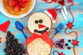 Funny oatmeal snowman with blueberry smile and strawberry nose. Festive idea for kids breakfast. New Year Christmas food top view Royalty Free Stock Photo