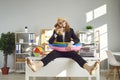 Funny office worker sitting on desk, drinking cocktail and waiting for summer holidays