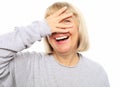 Funny old lady closes her eyes with her hand, peeps and laughs,  on white Royalty Free Stock Photo