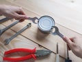 Funny opening tinned food. Funny geek girl trying to easy open a tin can with a wrench and pliers.