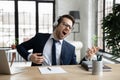 Funny overjoyed businessman wearing headphones pretending playing guitar in office