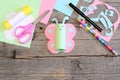 Funny paper butterfly, scissors, marker, glue stick, colored paper sheets and scraps, pencil on old wooden table Royalty Free Stock Photo