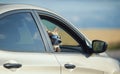 Funny passenger red corgi puppy dog in sunglasses pretty stuck his muzzle out of the car window while traveling summer sunny day Royalty Free Stock Photo