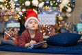 Funny pensive little girl writing letter to santa. kid making a wish, gift, present on new year eve. Royalty Free Stock Photo