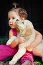 Funny photo of child cuddling beautiful golden labrador retriever puppy