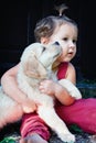 Funny photo of child cuddling beautiful golden labrador retriever puppy