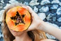 Happy baby boy eating orange papaya fruit on black beach Royalty Free Stock Photo