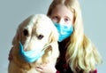 Funny photo - quarantined due to an epidemic of coronavirus. portrait of a masked dog and girl on a gray background.