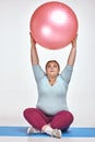Funny red haired, chubby woman is holding a ball