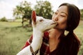 Funny picture a beautiful young asian girl farmer hugging white goat in countryside on grass. Royalty Free Stock Photo