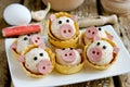 Funny pigs shaped snack tartlets stuffed with rice, surimi crab sticks, garlic and mayonnaise