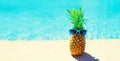 Funny pineapple with sunglasses on blue water pool background, summer holidays, vacation and food concept Royalty Free Stock Photo