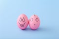 Funny pink eggs with face feeling on blue background Royalty Free Stock Photo