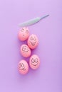 Funny pink eggs with face feeling on purple background Royalty Free Stock Photo