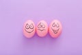 Funny pink eggs with face feeling on purple background Royalty Free Stock Photo