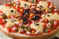 Funny pizza for Halloween with ham, cheese and vegetables close-
