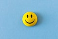 Funny plastic smiley face on a blue background. The concept of a positive mood
