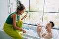 Funny playful asian couple lover play in the bathtub in the bathroom. Royalty Free Stock Photo